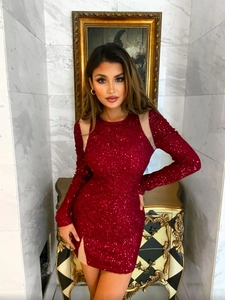 Détail d'une robe rouge à paillettes avec empiècement en maille à l'épaule et manche