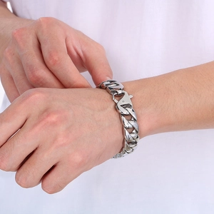 Silver 15mm Cuban link bracelet in titanium steel with spring clasp worn by a male model