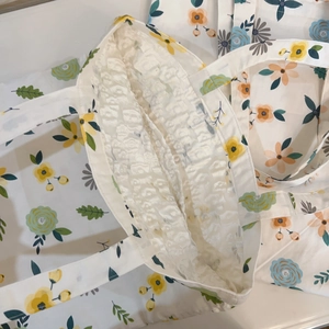 Detail of floral canvas tote bag featuring white lace lining and internal storage pocket