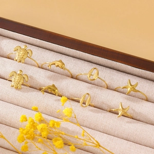 Detail view of gold ocean-themed rings including turtle, dolphin, and starfish designs