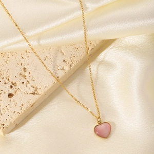 Elegant 18K gold plated heart necklace with pink stone on silk and stone background