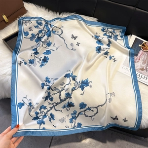 Eleganter Seidenschal mit Blumenmuster und Schmetterling auf weißem Stoff