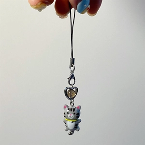 Detailed shot of a grey tabby cat charm with a silver heart bead and lobster clasp