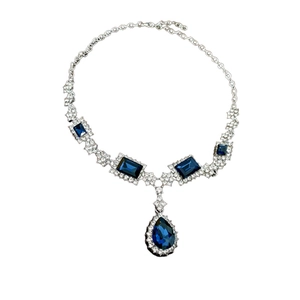 Elegant silver necklace set with blue square and teardrop crystal pendants and small gems