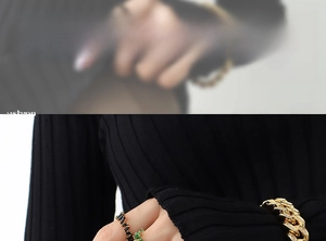 Detail of gold Cuban link bracelet with pavé diamonds and black stone ring on model