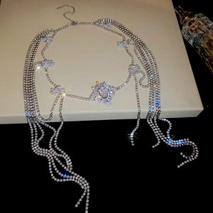 Detail of silver layered rhinestone body chain with floral patterns and tassel fringe