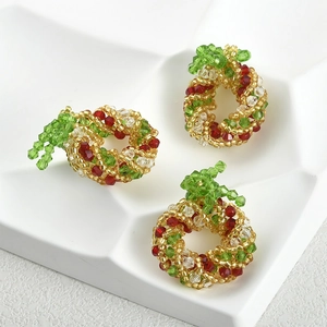 Macro shot of three handmade red and green beaded Christmas tree earring pendants