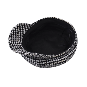 Detail of classic black and white houndstooth newsboy cap with premium lining