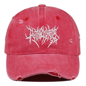 Close-up of distressed red baseball cap with white embroidery and frayed detail