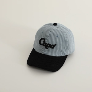 Macro detail of high-quality corduroy texture and 3D embroidered lettering on baseball cap