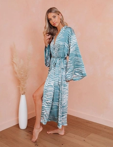 Detail view of long turquoise satin robe featuring white wave prints and side slits
