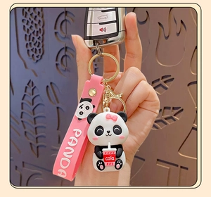 Detail of cartoon panda keychain with pink silicone strap and cola cup accessory