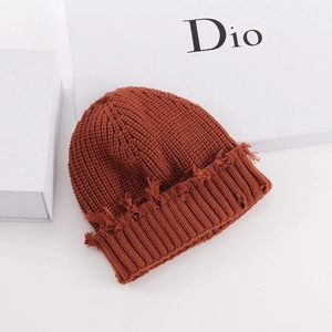 Detail of caramel knit beanie showing raw hem texture and vintage distressed design