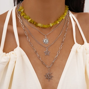 Detail of multi-layered silver chains with sun charms and yellow stone beads
