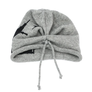 Detail of grey knitted beanie with black star pattern and adjustable drawstring