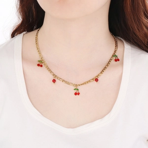 Close-up of 18K gold-plated stainless steel necklace with cherry pendants and red beads