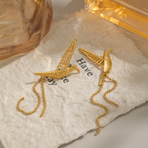 Vue détaillée des boucles d'oreilles colibri avec longs glands de chaîne en or