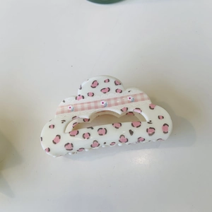 Detailed view of cream hair claw with leopard print pattern and floral plaid ribbon