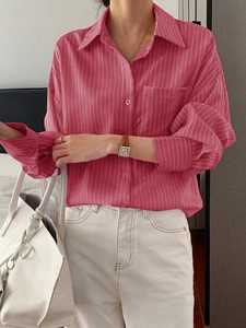 Close-up of pink striped long-sleeved shirt with white bag and casual accessories
