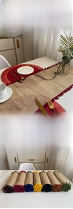 Detail of jute table runner with decorative colorful pom-pom trim and rolled storage design