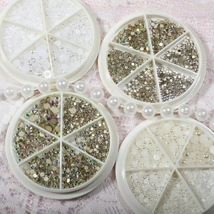 Flat lay of nail art DIY set with pearls and rhinestones in four 6-grid carousel wheels