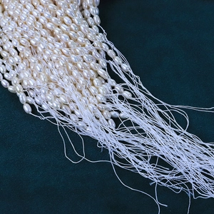 4-4.5mm natural white rice pearls for DIY jewelry making on dark teal background