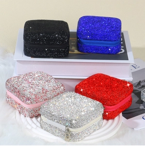 Close-up of sparkling rhinestone jewelry boxes in five colors with zipper closures