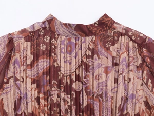 Detail of bohemian paisley print on pleated chiffon fabric with dark red stand-up collar