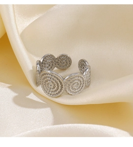 Close-up of silver stainless steel spiral ring showing detailed woven texture on silk fabric