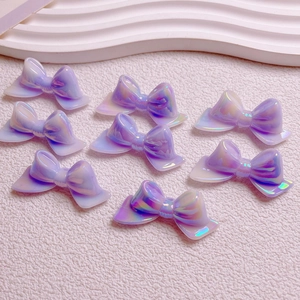 Detailed view of iridescent purple resin bow beads with dual-tone finish for DIY jewelry