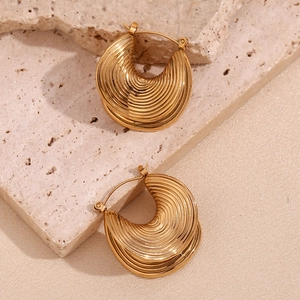 Detailed close-up of gold plated ribbed hoop earrings with a textured surface finish