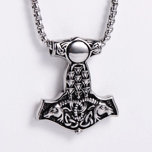 Gros plan du pendentif Marteau de Thor argenté avec motifs d'animaux nordiques et textures