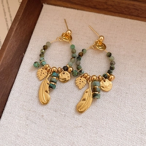 Detail of vintage bohemian earrings with turquoise beads and golden leaf pendants