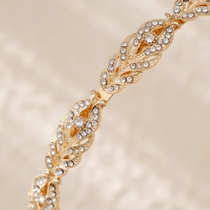 Close-up of golden wheat ear headband featuring sparkling rhinestones and leaf pattern