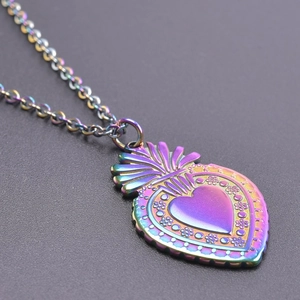Vue macro du pendentif cœur fraise avec finition irisée et détails floraux ciselés