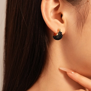 Retro black resin beaded basket hoop earrings with gold finish on female model