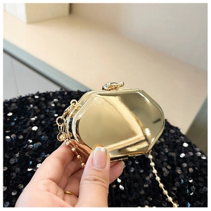Detailed macro of gold geometric mini metal bag with mirrored finish and chain strap