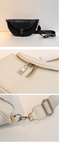 Close-up of litchi grain leather texture and durable silver metal zippers on the handbag