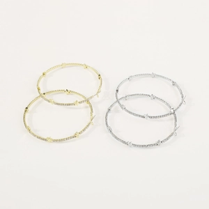 Macro di grandi orecchini a cerchio oro e argento con strass scintillanti e piccole stelle