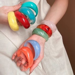 Detailed view of colorful marbled resin bangles featuring vibrant artistic swirl patterns