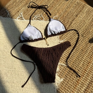 Detailed macro view of chocolate brown textured bikini with starfish and pearl charms