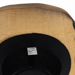 Detail of cowboy sun hat interior showing woven paper texture and black sweatband
