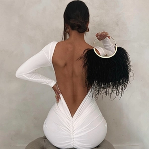Detail of white backless bodycon dress with ruching and feather handbag with gold handle