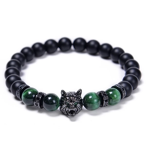 Detail of wolf head charm with green tiger eye and black matte beads bracelet