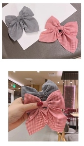 Detail of red and black checkered bow hair clips set with cotton fabric texture