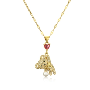 Gold bear pendant necklace with red heart stone, sparkling zircon, and pearl drop on white