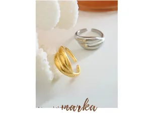 Macro detail of chunky gold and silver twisted open rings on minimalist background