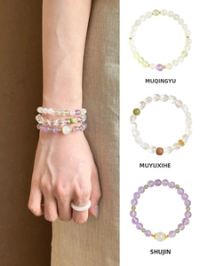 Detailed view of natural amethyst and green aventurine beaded bracelets with gold spacers