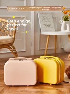 Detail of pink and yellow mini hard shell suitcases with dual zippers and sturdy handles