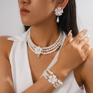 Macro detail of multi-layer pearl necklace with rhinestone flower and teardrop pendants